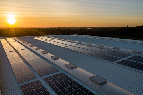 3-IYASU-Conserve-Energy embracing sustainable living: flat roof with solar panels during sunset